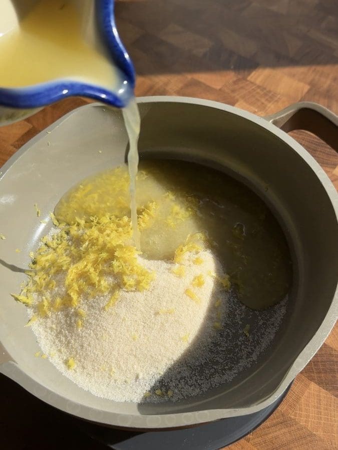 Pouring lemon juice into a saucepan.