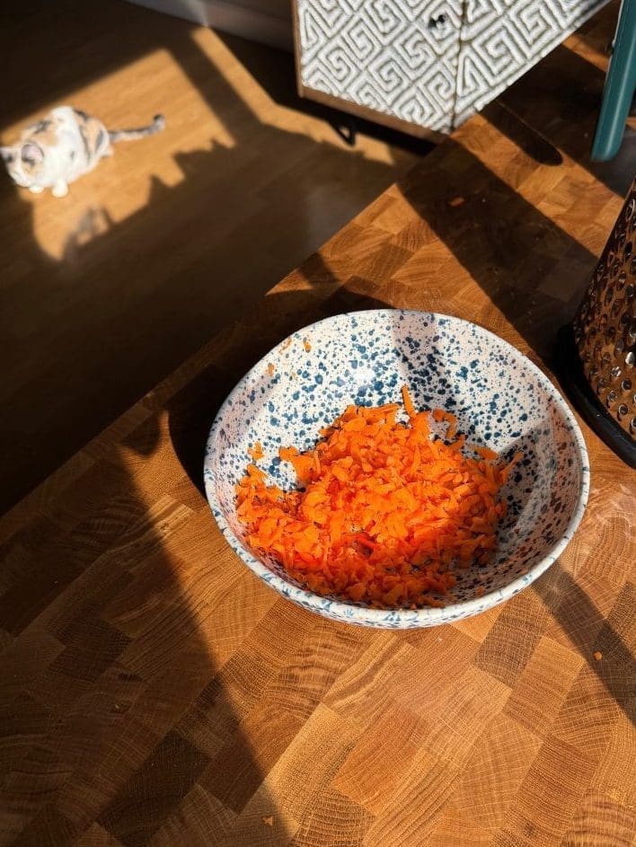 Shredded carrots in a mixing bowl.