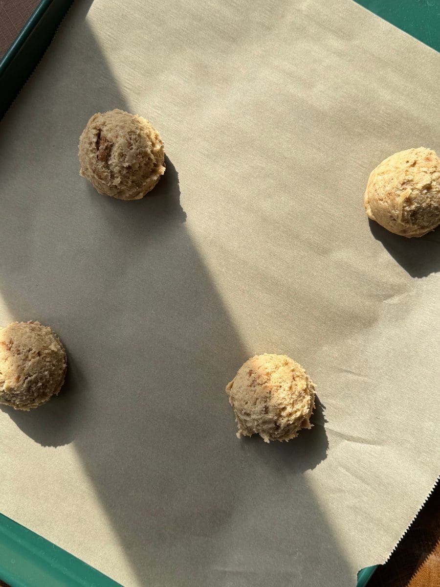 The scoops of dough on a baking tray.