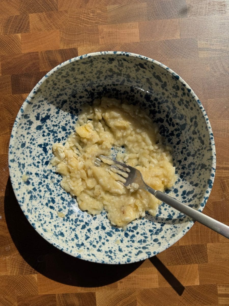 Banana mashed in a mixing bowl.