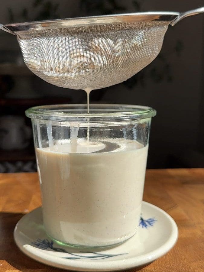 Straining the rice out of the horchata.