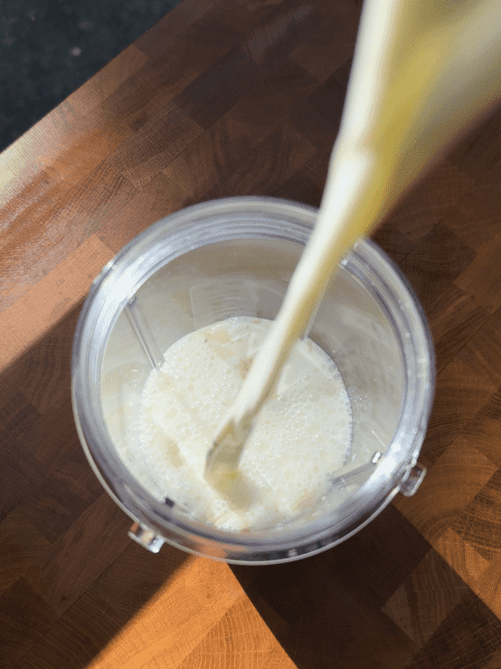 Pouring milk into a blender.
