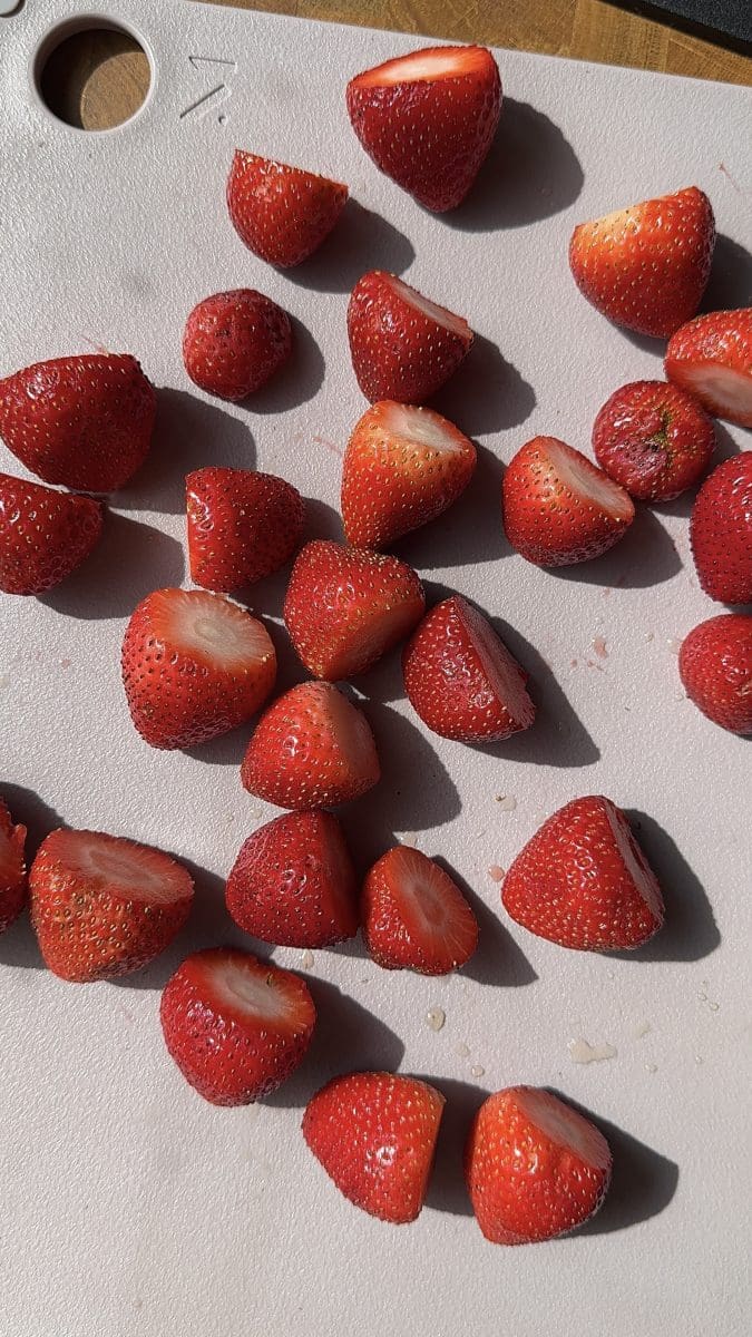 Chopped strawberries on a cutting board.