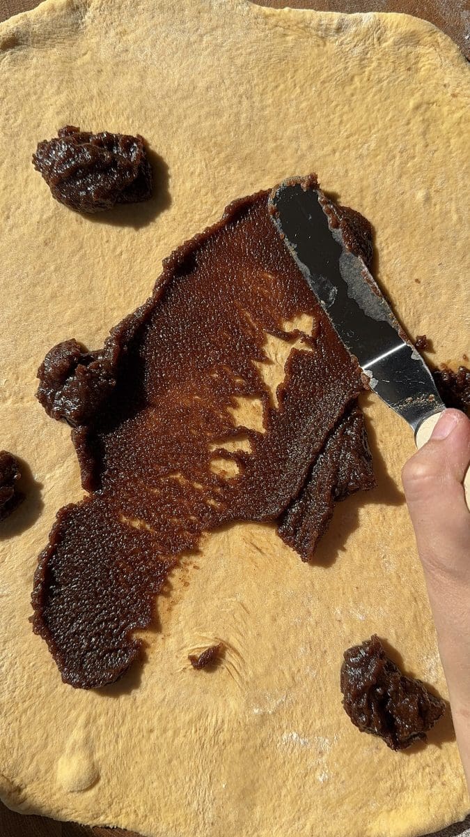 Spreading the spiced sugar mixture over the dough.