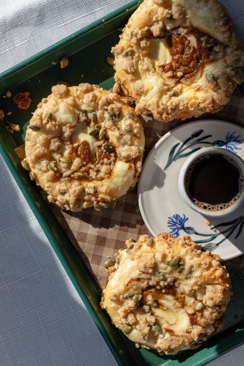 The pumpkin cheesecake brioche buns on a tray with espresso.