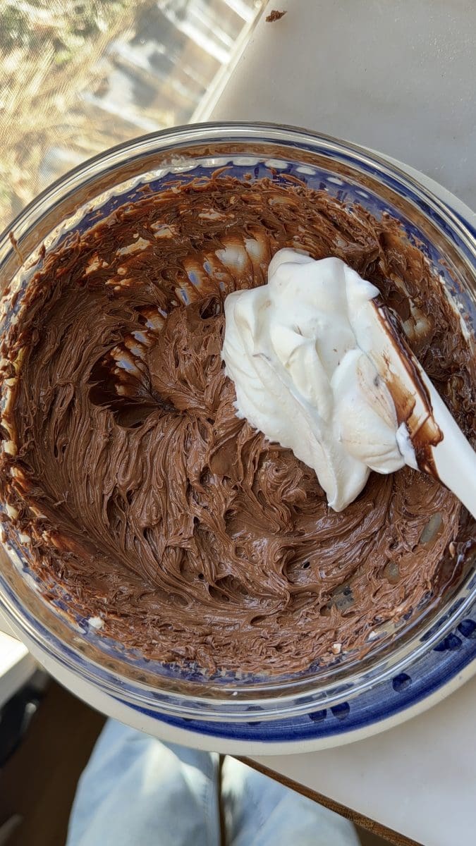 Folding whipped cream into the custard.