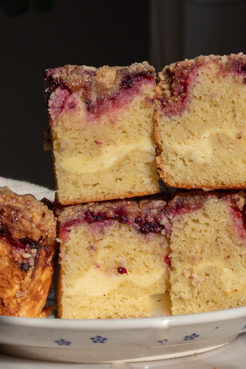 Pieces of berry cream cheese crumb cake stacked on top of each other.